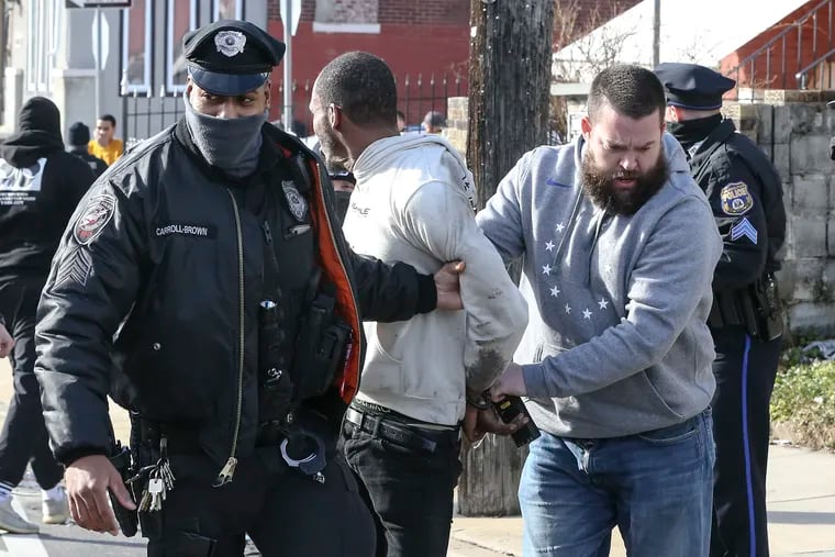 Philadelphia Police and SEPTA Police take a man into custody a half-block away from Broad and Olney. Feb. 17, 2021.