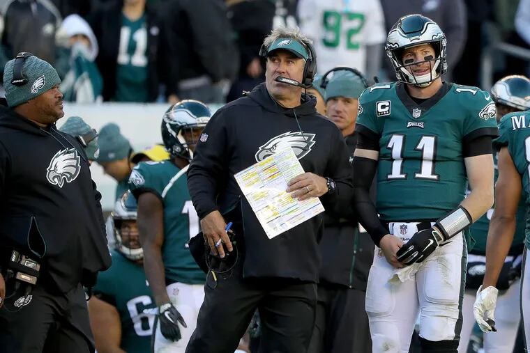 Eagles head coach Doug Pederson, center, and Carson Wentz talk as they wait for an instant replay in the 4th quarter. Philadelphia Eagles lose 21-17 to the Carolina Panthers in Philadelphia, PA on October 21, 2018. DAVID MAIALETTI / Staff Photographer