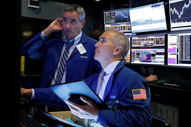 FILE - In this Oct. 2, 2019, file photo traders Daniel Trimble, left, and Timothy Nick work on the floor of the New York Stock Exchange.