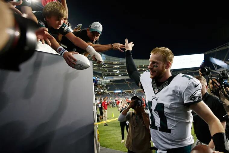 Eagles’ Carson Wentz high-fives fans after the Eagles' 29-14 win over the Chicago Bears at Soldier Field in Chicago.