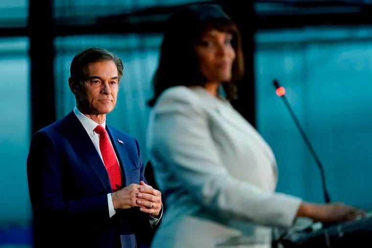 Mehmet Oz, left, looks on as Kathy Barnette finishes her remarks during a Republican primary forum in May.