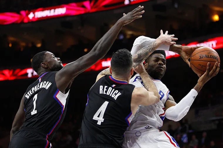 Philadelphia 76ers' Nerlens Noel (4) tries to shoot with Los Angeles
Clippers' J.J. Redick (4) and Lance Stephenson (1) defending during
the first half of an NBA basketball game, Monday, Feb. 8, 2016, in
Philadelphia.