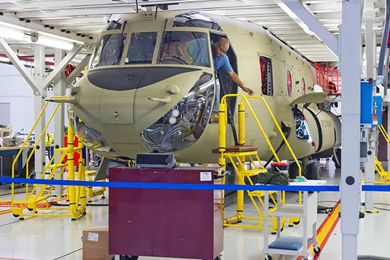 Tony Britt of Oxford, Pa. exits the cockpit of a Chinook helicopter in the Pre-Flight Test Area at the Boeing Plant, Ridley Park, October 23, 2012. The U.S. Army Inspector General's Office says Boeing overcharged taxpayers by as much as $16 million by using used parts instead of new parts on the CH-47 Chinook helicopters it makes in Ridley, Delaware County. ( DAVID M WARREN / Staff Photographer )