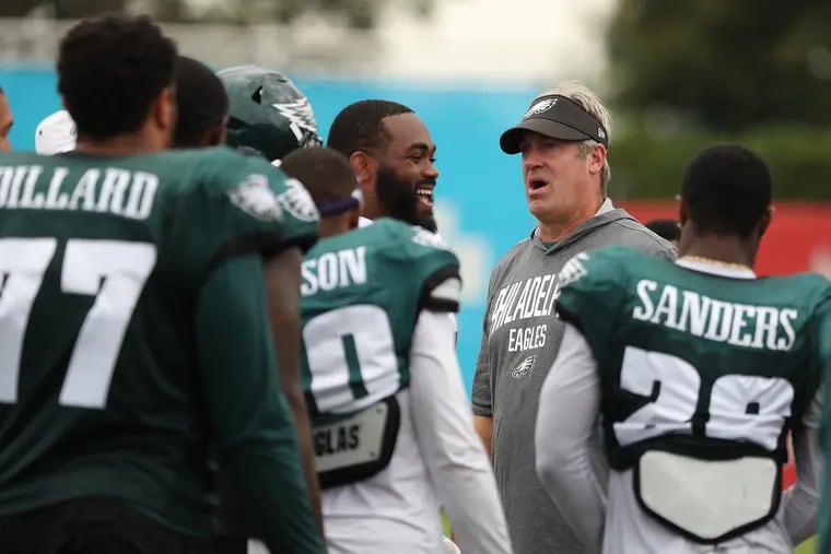 Eagles head coach Doug Pederson, right, talks with his players at Eagles training camp last August.