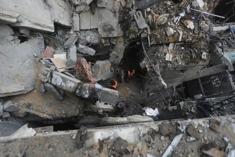 Palestinians look at the destruction after an Israeli strike on residential building in Rafah, Gaza Strip, on Tuesday.