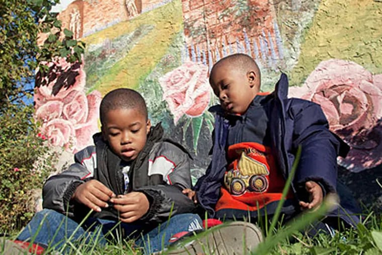 Children sit in Winding Roses Park in the city's Francisville neighborhood.