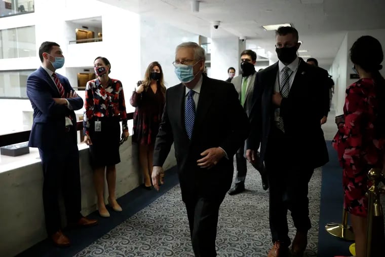 Senate Majority Leader Mitch McConnell, center, walking past staffers on Capitol Hill on Tuesday.