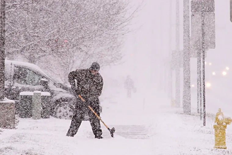 Matthew Kemeny shovels the sidewalk outside the McDonald's restaurant he manages in West Bend, Wis. Snow is expected for the rest of the week. JOHN EHLKE / West Bend Daily News
