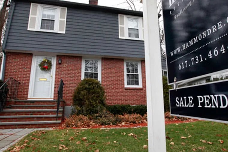 In this Dec. 27, 2011 photo, a sale pending sign hangs in front of a single-family home in Brookline, Mass. The number of Americans who signed contracts to buy homes in November rose to the highest level in a year and a half. (AP Photo/Steven Senne)