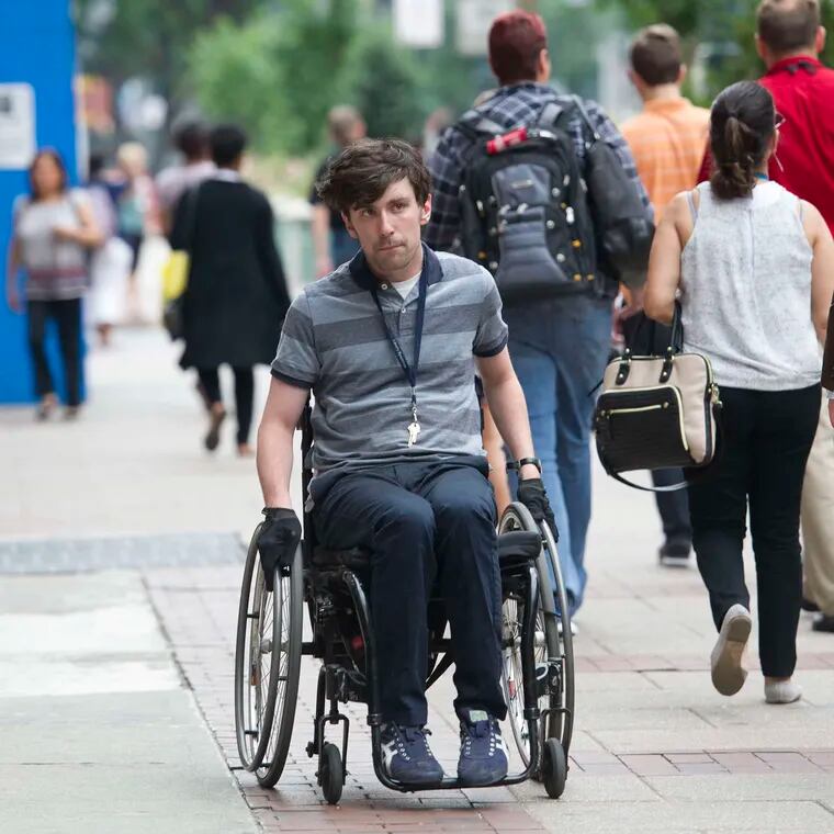 Liam Dougherty was a plaintiff in a suit accusing the city of violating federal protections for people with disabilities with inaccessible sidewalks and curb ramps. He is shown here in a 2019 file photo.