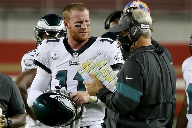 Does Eagles coach Doug Pederson (right) still have faith in Carson Wentz? It's hard to tell from what he's saying.