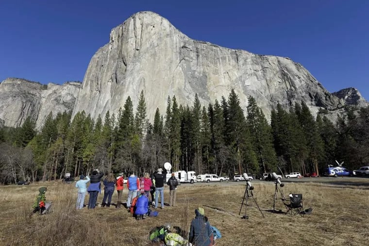 FILE – In this Jan. 14, 2015, file photo, spectators gaze at El Capitan for a glimpse of climbers Tommy Caldwell and Kevin Jorgeson, as seen from the valley floor in Yosemite National Park, Calif. The Interior Department is backing down from a plan to impose steep fee increases at popular national parks after widespread opposition from elected officials and the public.