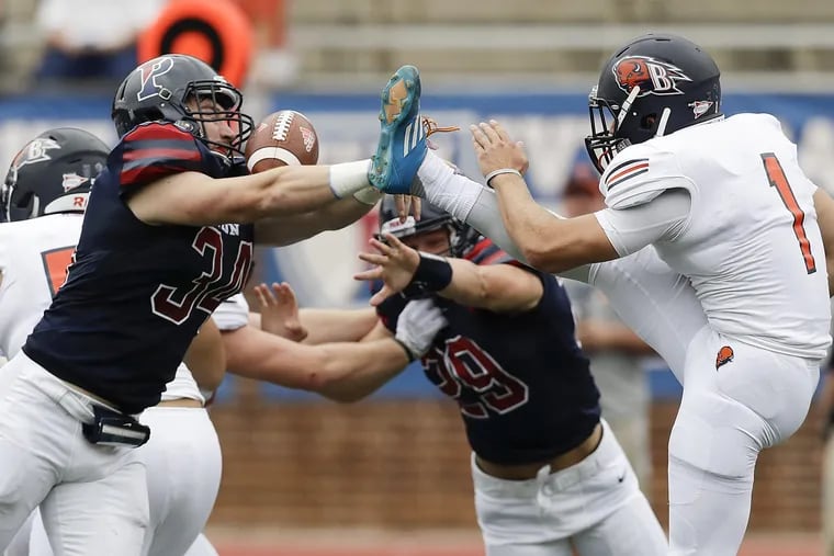 Penn linebacker Patrick McGettigan blocks a first-quarter punt by Bucknell's Alex Pechin. The Quakers took advantage of early defensive momentum to seal the season-opening win.