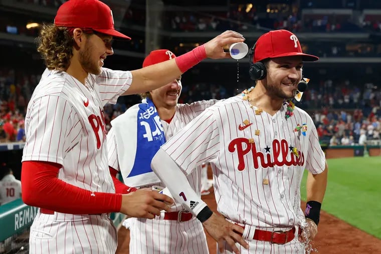Phillies shortstop Trea Turner celebrates with teammates third baseman Alec Bohm and second baseman Bryson Stott after the Phillies' 9-6 win over the Kansas City Royals on Saturday.