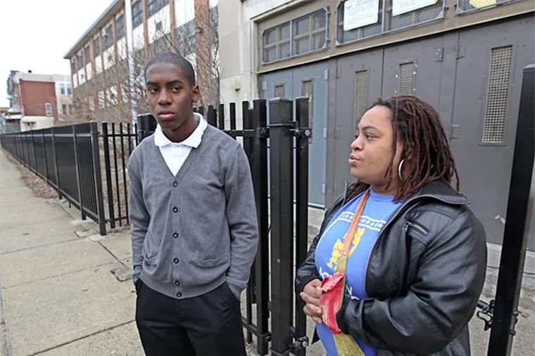 Khyrie Brown, left, and his mother Dawn Hawkins, right, stand outside Blaine Elementary School waiting for SRC Chairman Bill Green to show up for a tour of the school on Monday morning.