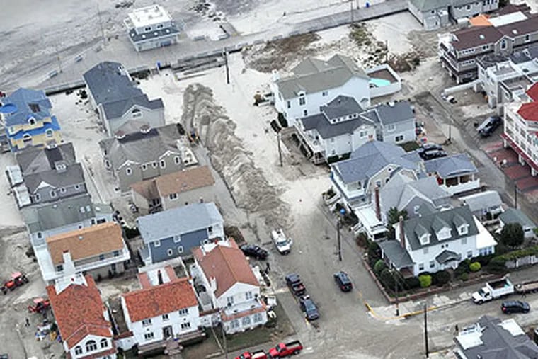 In Ocean City, homeowners and clean-up crews descend on First Street (center) and St. James Place (left). (Clem Murray / Staff Photographer)