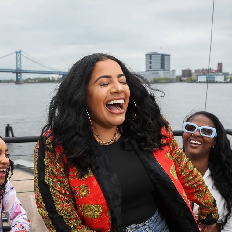 Delilah Dee, center, founder of Jefatona, DJ Flakka, left, and DJ Bria G, right, laugh while posing together for a photo on the rooftop of Liberty Point in Philadelphia. Jefatona, Philly's reggaeton and Caribbean party created to be a safe space for women, will have their own exclusive space at El Movimiento's Cinco de Mayo Festivale on the waterfront.