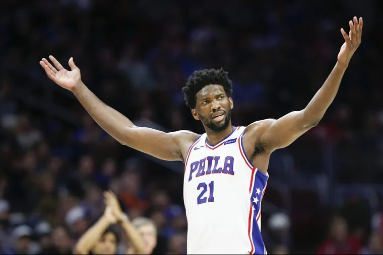 Sixers center Joel Embiid plays to the crowd during the victory over  the Clippers on Saturday.