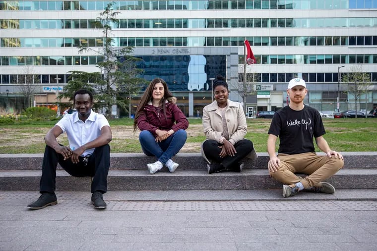 From left are the founders of Centre Francophone De Philadelphie: Mamadou Ndiaye, of Senegal, Amel Kherbachene, of Algeria, Nahomie Laurore, of Haiti, and Ben Goebel, of France. They posed for a portrait in Love Park on Wednesday.