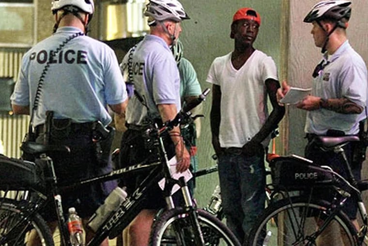 Police discuss Philly's new curfew laws with a young person last weekend. (Staff photo)