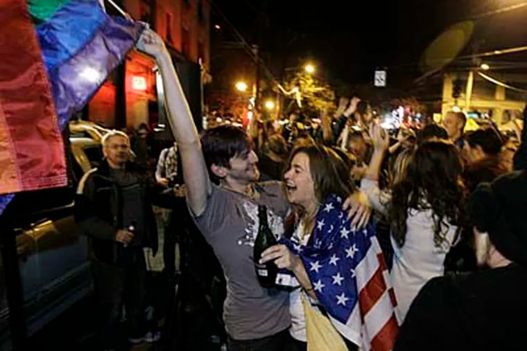 Revelers display U.S. and gay pride flags as they celebrate early election returns favoring Washington state Referendum 74, which would legalize gay marriage, during a large impromptu street gathering in Seattle's Capitol Hill neighborhood, in the early hours of Wednesday, Nov. 7, 2012. (AP Photo/Ted S. Warren)