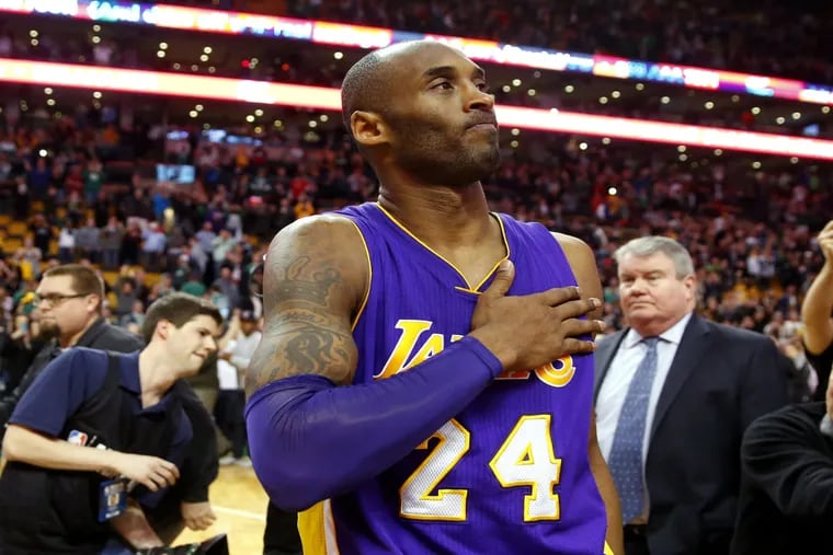 Los Angeles Lakers' Kobe Bryant touches his chest as he walks of the court in Boston after the Lakers' 112-104 win over the Boston Celtics in an NBA basketball game on Wednesday, Dec. 30, 2015.