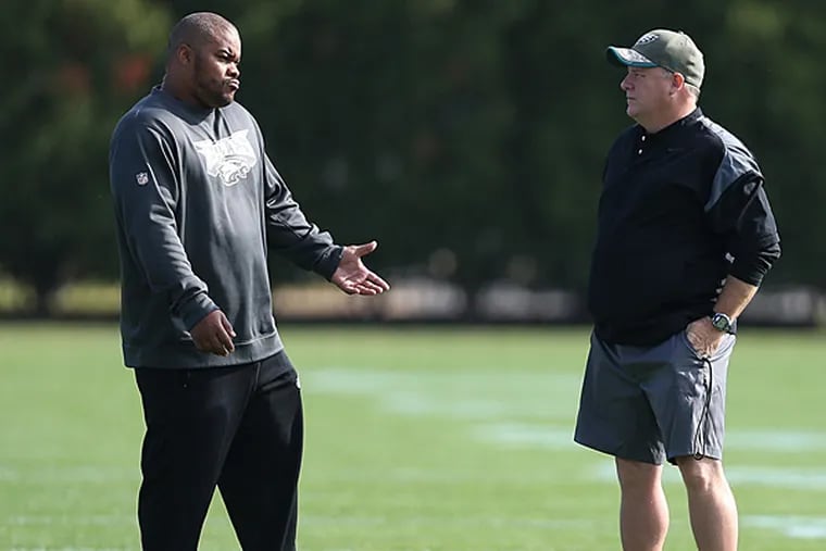 Eagles' running back coach Duce Staley, left, talks with head coach Chip Kelly, right, during Eagles practice at the NovaCare Complex in Philadelphia on November 12, 2014. (David Maialetti/Staff Photographer)