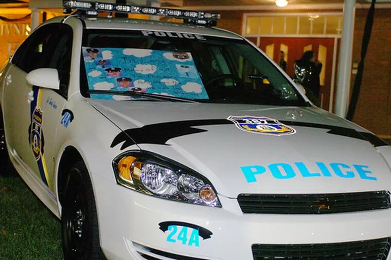Car 24A, the police cruiser driven by Sgt. Timothy Simpson, is decorated with tributes and parked in front of John F. Givnish Funeral Home, where the officer&#0039;s viewing was held last night.