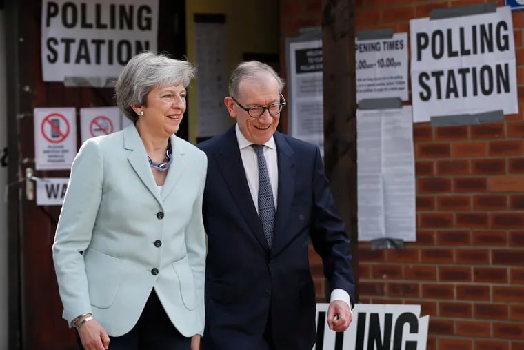 Britain's Prime Minister Theresa May and her husband, Philip, leave a polling station after voting in the European Elections in Sonning, England, Thursday, May 23, 2019.