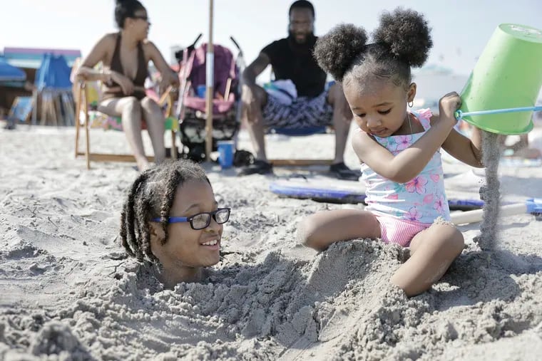 Staying cool, covered in sand is Joseph Stanton IV, 10, and sister Aylah Stanton, 2, play with family at the beach in Ocean City in May 2022. Summer is full of fun activities, but can also be a stressful time for parents.
