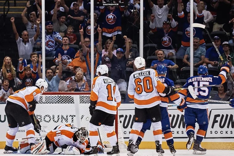 The Islanders' Cal Clutterbuck (right) celebrates after scoring, during the first period of a preseason game Sunday against the visiting Flyers.