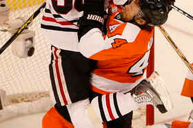 Blackhawks' Dave Bolland collides with Flyers' Kimmo Timonen in the second period.