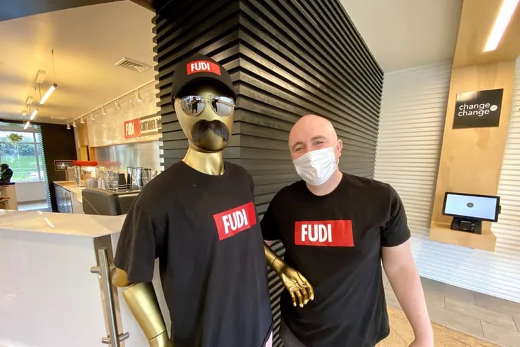 Founder Bryn Davis at the Plymouth Meeting location of Fudi Fast Food with Frank, the mascot.