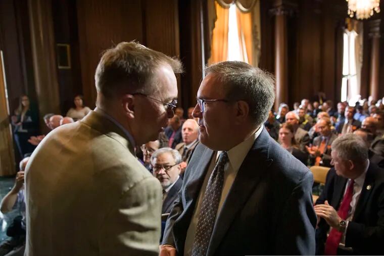 Acting White House Chief of Staff Mick Mulvaney, left, shakes hands with EPA administrator Andrew Wheeler after Wheeler signed the Affordable Clean Energy Rule at the Environmental Protection Agency, Wednesday, June 19, 2019, in Washington. Wheeler signed a repeal of one of the Obama era's two biggest climate change initiatives, the Clean Power Plan, and adopting an alternative plan that would loosen regulations on the plants.