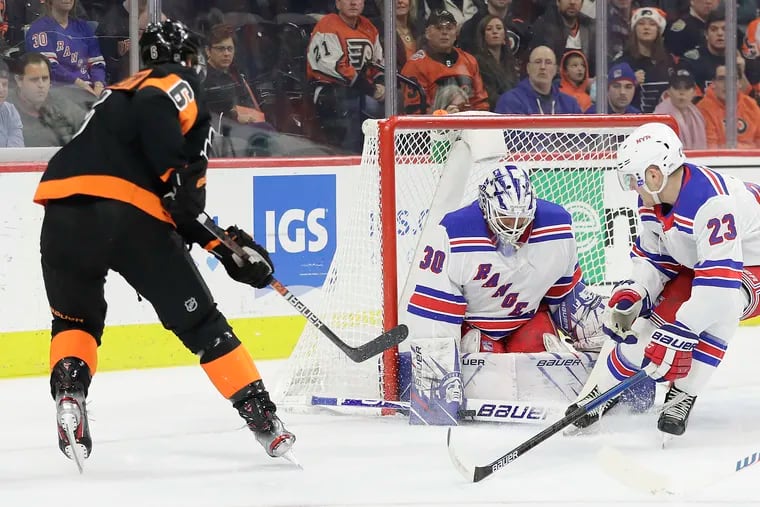Rangers goaltender Henrik Lundqvist stops the puck with teammate Adam Fox against the Flyers' Travis Sanheim.