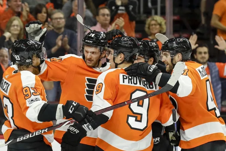 Flyers center Sean Couturier (second from left) celebrates one of his goals with teammates Saturday against Washington.