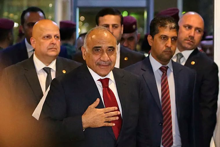 FILE - In this Oct. 24, 2018 file photo, then Prime Minister-designate Adel Abdul-Mahdi, center, arrives to the parliament building, in the heavily guarded Green Zone, in Baghdad, Iraq. Abdul-Mahdi told reporters at a press conference on Monday, Dec. 24, 2018, that his government could deploy troops inside Syria, in the latest fallout from the U.S. decision to withdraw from the war-torn country. The prime minister said his government is "considering all the options" to protect Iraq from threats across its borders. (AP Photo/Hadi Mizban, File)