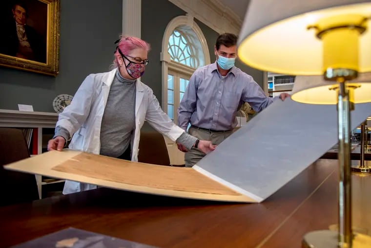 American Philosophical Society's head of conservation Anne Downey, left, and Patrick Spero, director of the library, open their copy of the original Declaration of Independence ordered up by President John Quincy Adams in 1820, but not completed until 1823. (Tom Gralish/The Philadelphia Inquirer/TNS)