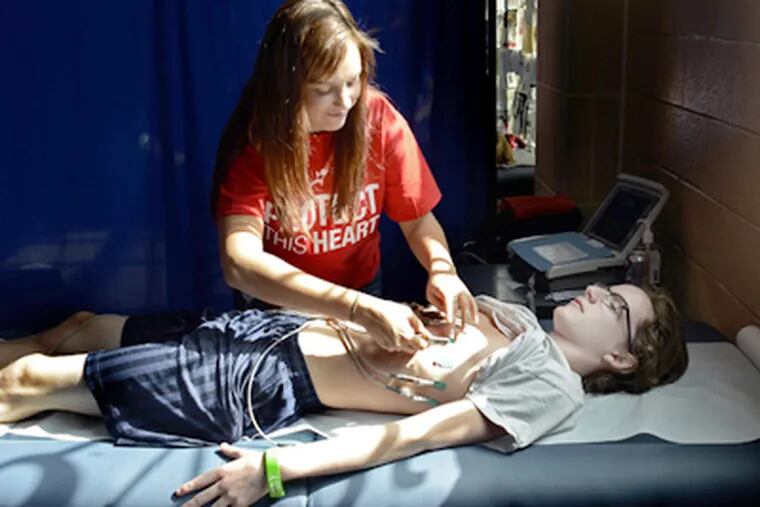 Alison Buchinsky of the Children's Hospital of Philadelphia prepares Sean Griffin, 14, for a heart screening at Upper Dublin High. More than 300 young athletes were screened. (Tom Gralish / Staff Photographer)