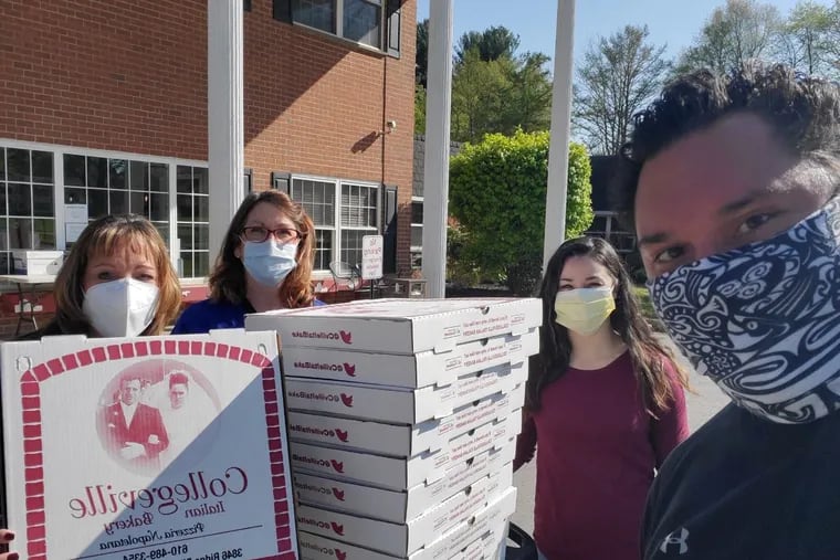 Joe Kekoanui (right) of the Bama Booster Club of Bridgeport delivers pizzas to nurses at Aristacare at Meadow Springs in Plymouth Meeting. The nurses, from left to right, are Donna Winsey Clement, Amanda Baum, and Helena Wagenmann.