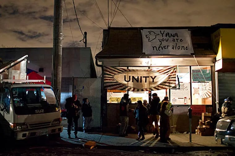 In New York's Queens borough , volunteers and those needing help stand outside a center where Occupy Sandy had set up to aid people in Rockaway Park. CRAIG RUTTLE / Associated Press