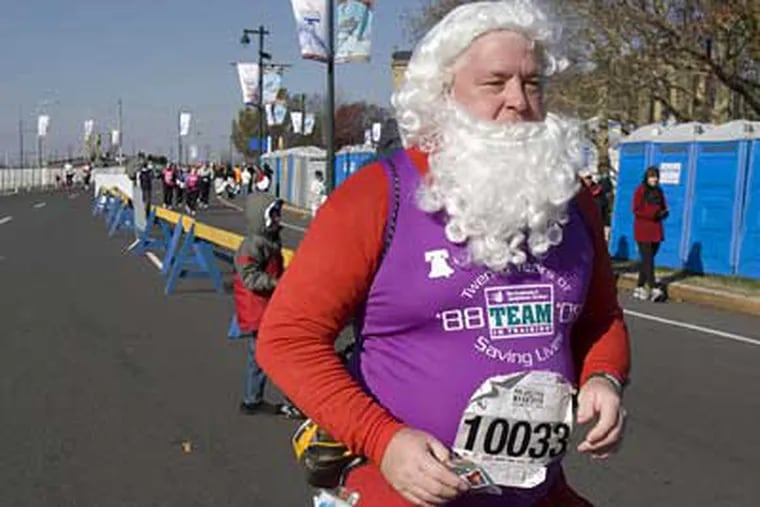 Robert Bevan, dressed as Santa Claus, rounds Logan Circle while running in the 2008 Philadelphia Marathon on Sunday.  (Ed Hille / Staff Photographer)