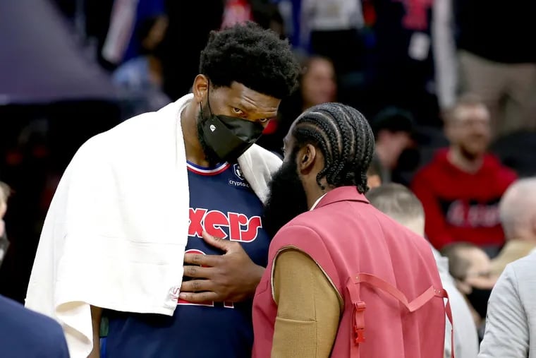 Joel Embiid, left, and James Harden of the Sixers talk during a timeout late in their game against the Celtics at the Wells Fargo Center on Feb. 15, 2022.