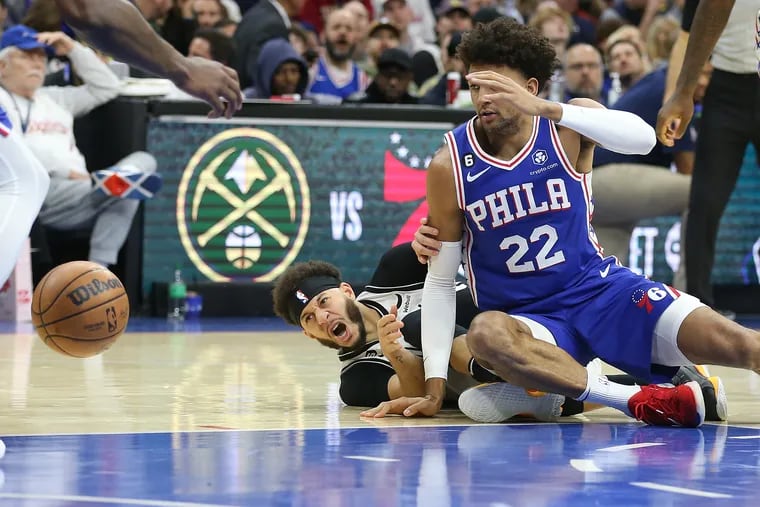 Matisse Thybulle (right) of the Sixers and Seth Curry of the Nets go after a loose ball during the 2nd half of their game at the Wells Fargo Center on Jan. 25, 2023.