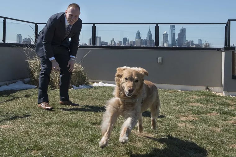 Josh Winigrad lets his golden retriever mix, Daisy, out for a run in the rooftop dog park, one of the amenities that lured Winigrad to the IceHouse Community in Fishtown.
