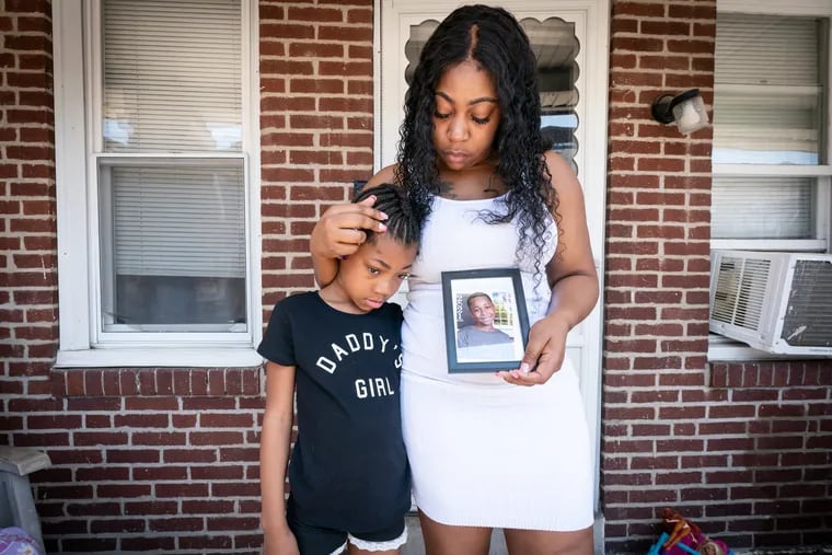 Vanessa Frame with her daughter Janiyah Parks, 7, with a photograph of her son Jamel Parks, 9, who was shot and killed along with his father on Sunday.