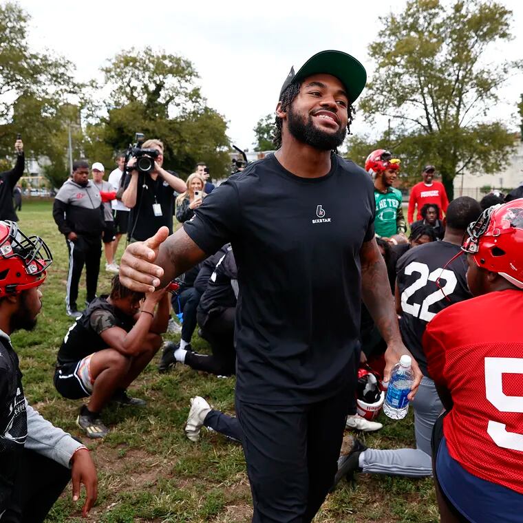 Eagles running back D’Andre Swift greets Imhotep Institute Charter High School football players as they prepare for their game against Abraham Lincoln at the Lonnie Young Recreation Center field in the Orontz section of Philadelphia on Monday, Sept. 18, 2023