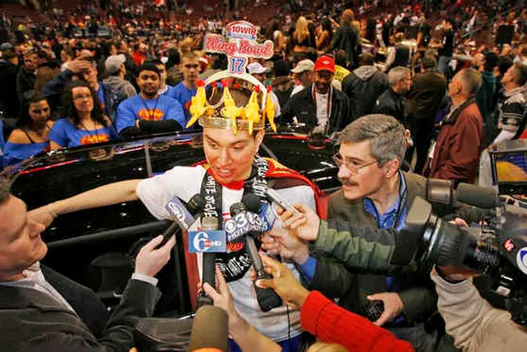 Don&#0039;t get those mics too close to his maw: Jonathan Squibb, king of Wing Bowl 17 at the Wachovia Center, talks to reporters. Usually a healthful eater, he won an extra incentive not to expand - a Mini Cooper. (See &quot;Winging it.&quot;)