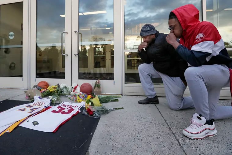Arnold Haynes and his son AJ Haynes, 16, of Lower Merion, pray at a makeshift memorial to Kobe Bryant just outside of the Bryant Gymnasium at Lower Merion High School. Arnold, who is three years older than Bryant, played pickup basketball with him growing up; AJ is a junior at the school.  Bryant and eight others, including his daughter, Gianna, died in a helicopter crash on January 26, 2020.