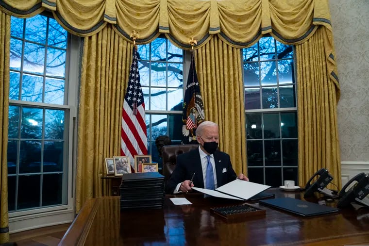 President Joe Biden signs a series of executive orders in the Oval Office of the White House in Washington.